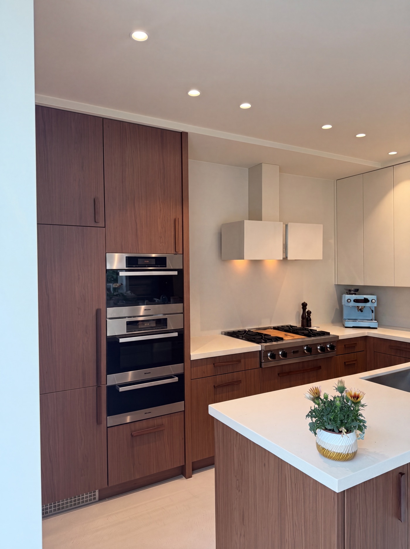 De keuken van Paulien na het wrappen, met warme houtlookfronten en een licht keukeneiland